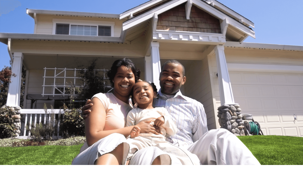 A happy family is sitting in front of a house that was completed under the sponsorship of the NYSERDA program.