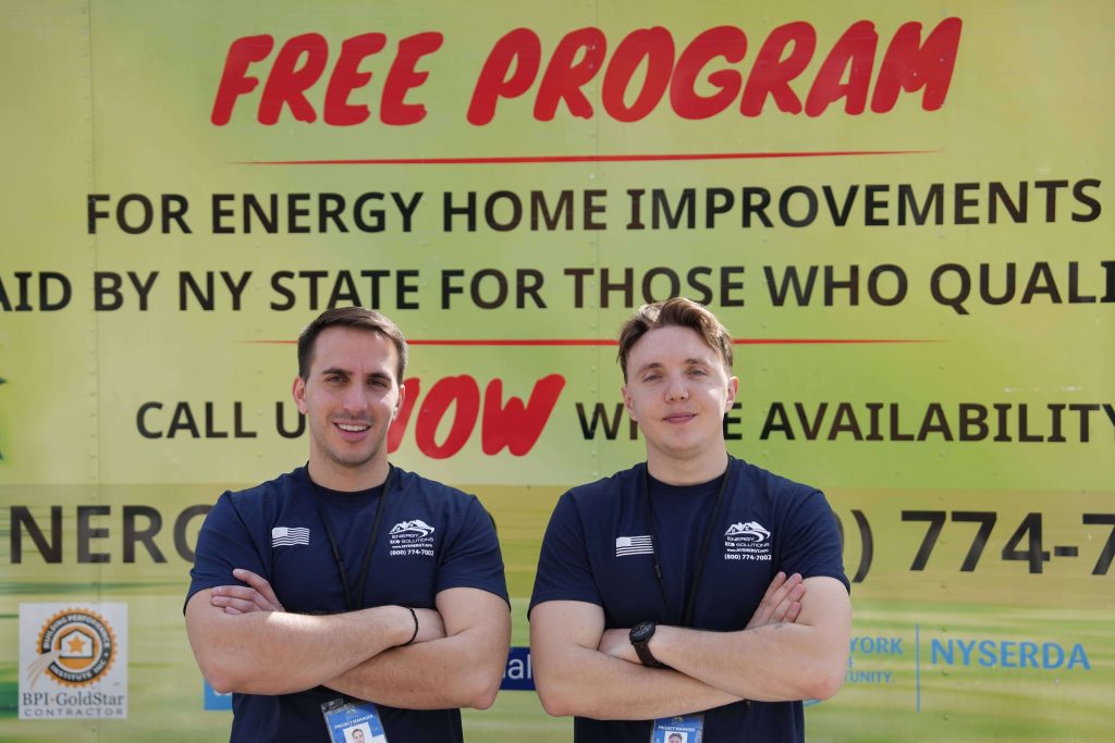 two workers of energy eco solutions in front of the truck with a equipment for blown in cellulose insulation